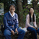 Hirayama and his niece Niko sit on a bench and look up smiling.